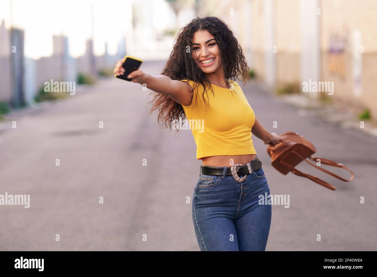 Happy Arab woman wearing casual clothes with open arms in the street.. Happy Arab woman with open arms in the street. Stock Photo