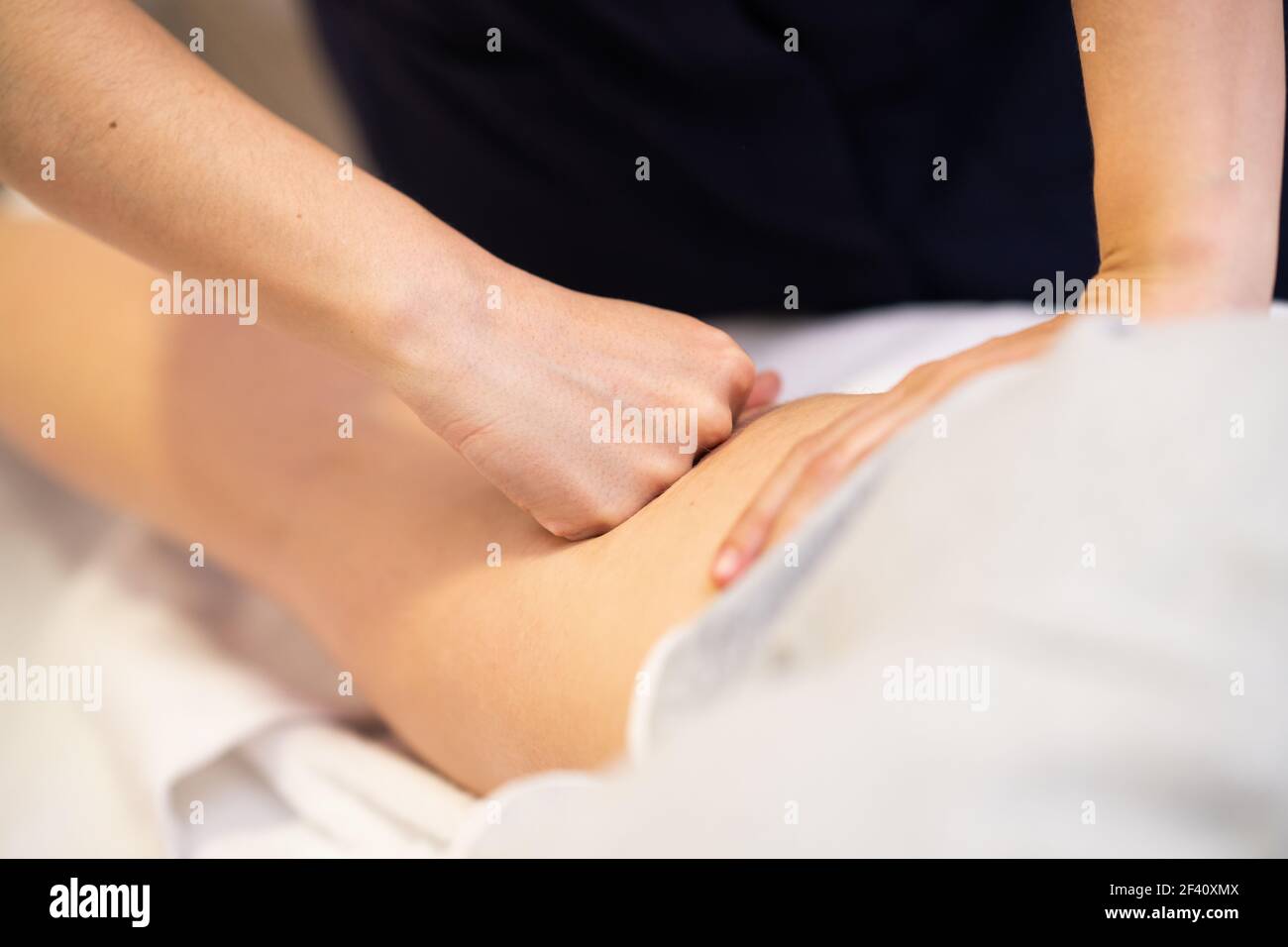 Medical massage at the leg in a physiotherapy center. Female physiotherapist inspecting her patient.. Medical massage at the leg in a physiotherapy center. Stock Photo