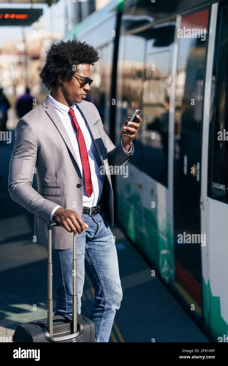 Black Businessman waiting for the next train. Man with afro hair commuting.. Black Businessman waiting for the next train Stock Photo