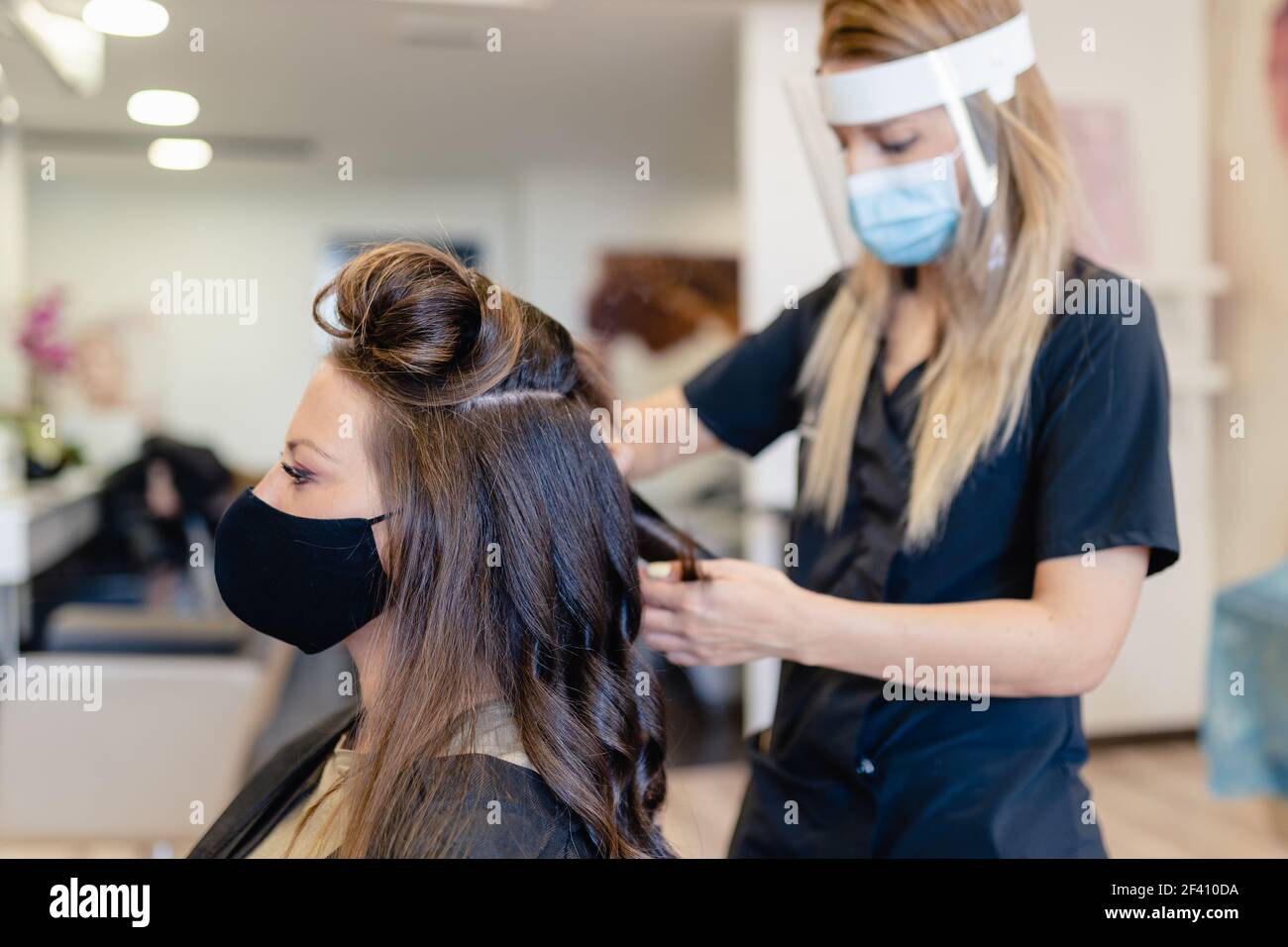 Hairdresser Protected By A Mask Making Waves In Her Client s Hair