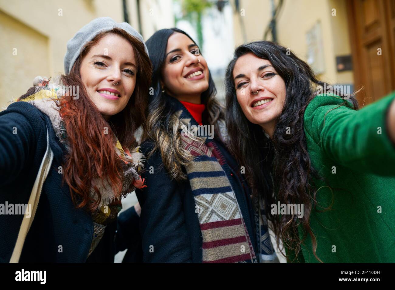 Multiethnic group of three happy woman taking a selfie photo with a ...