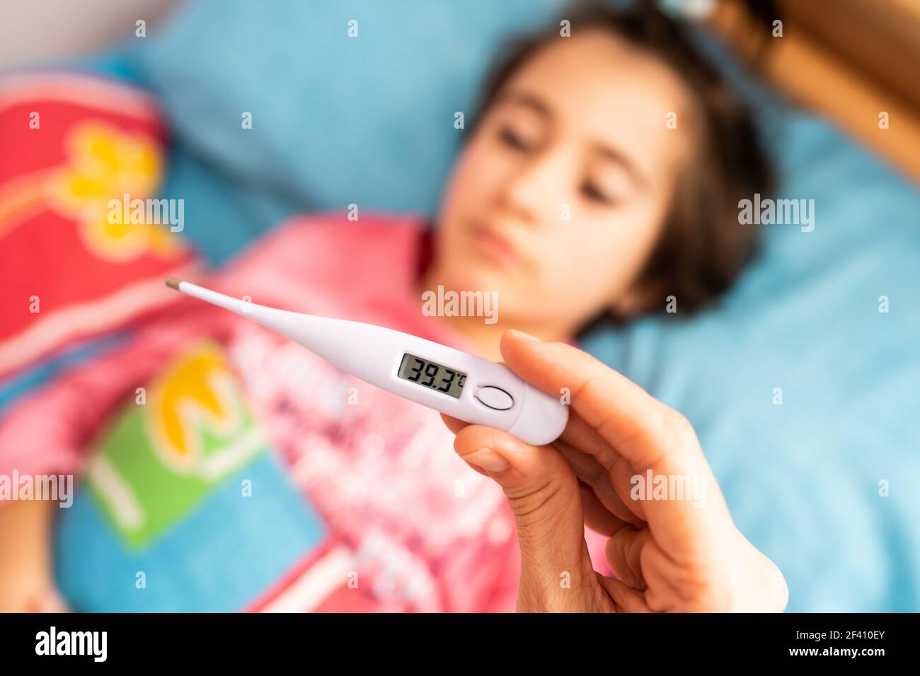 Mother measuring her toddler’s temperature with a digital thermometer