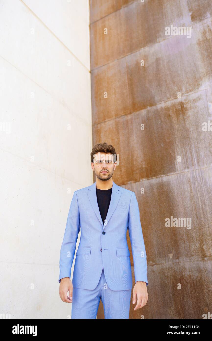 Attractive young man wearing suit standing outdoors.. Attractive man wearing suit standing in urban background. Stock Photo