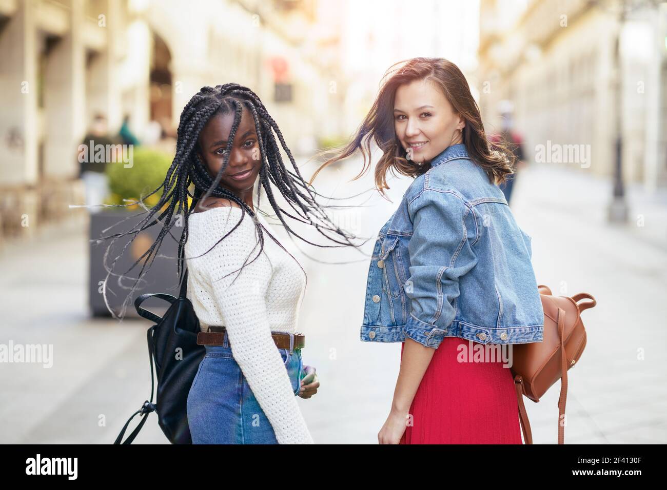 Two friends having fun together on the street. Multiethnic women.. Two female friends having fun together on the street. Multiethnic friends. Stock Photo