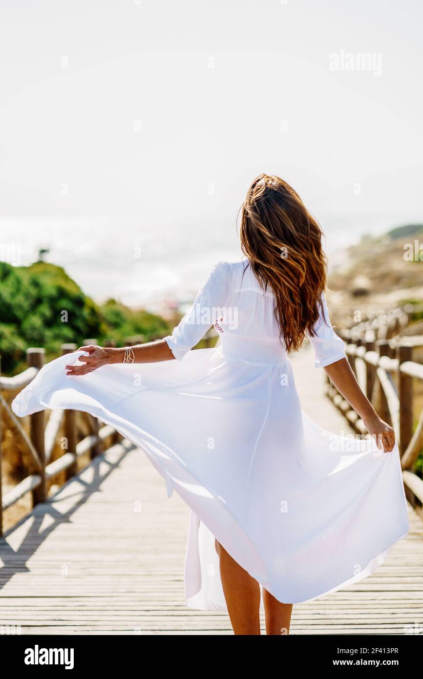 Rear view of a young woman wearing a beautiful white dress in Spanish