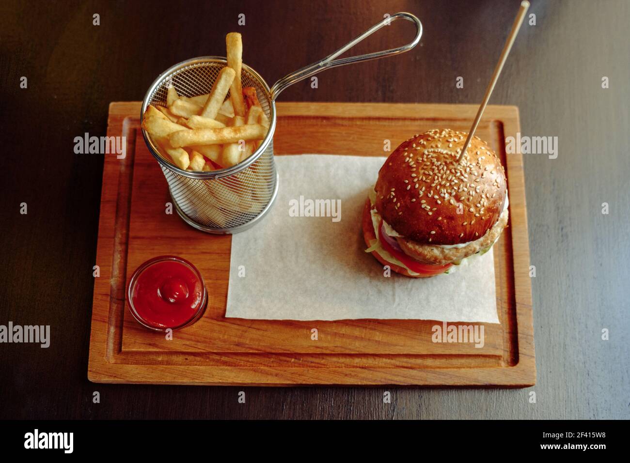 Fresh delicious halal burger with french fries, tomato sauce on the wooden plate top view.. Delicious burger with french fries, tomato sauce on the wooden plate top view. Stock Photo