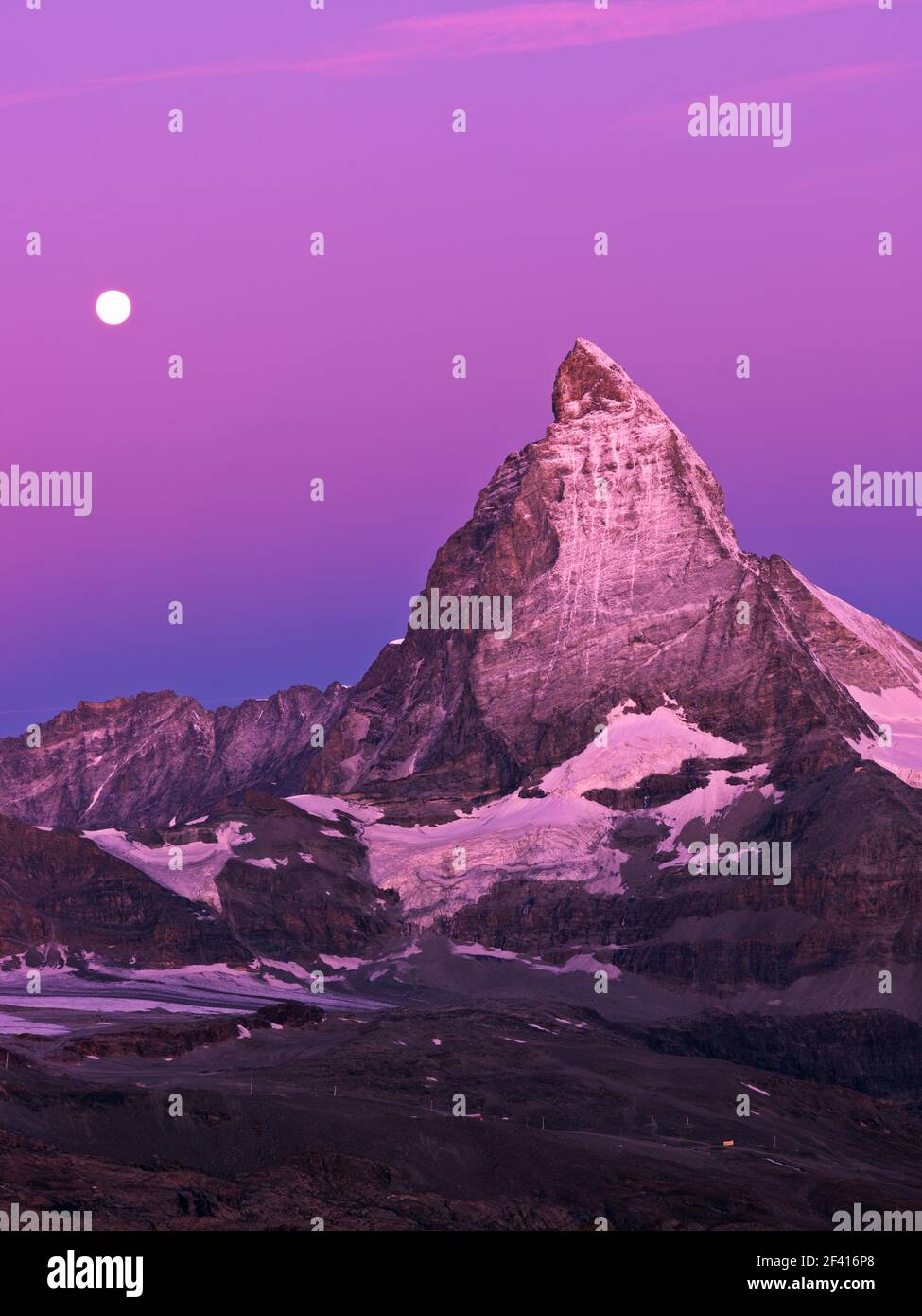 moon setting behind the Matterhorn at dawn Stock Photo