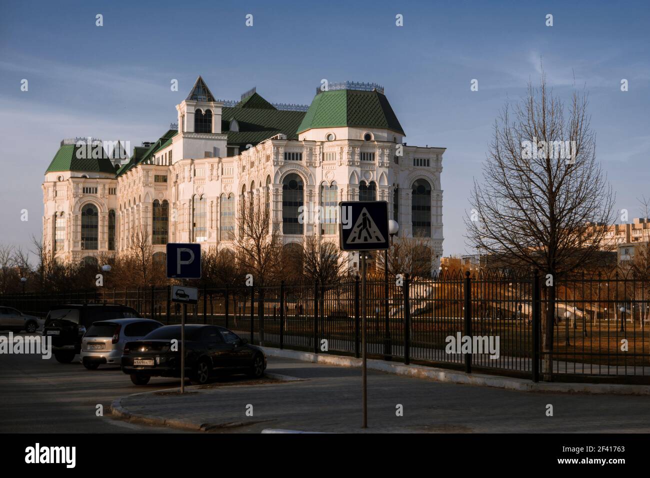 Astrakhan, Russia 12 of April 2018: New Astrakhan Opera Theater In Sunny Spring Day With Cars Parked About. Angle View.. Astrakhan, Russia 12 of April 2018: New Astrakhan Opera Theater In Sunny Spring Day With Cars Parked About. Stock Photo