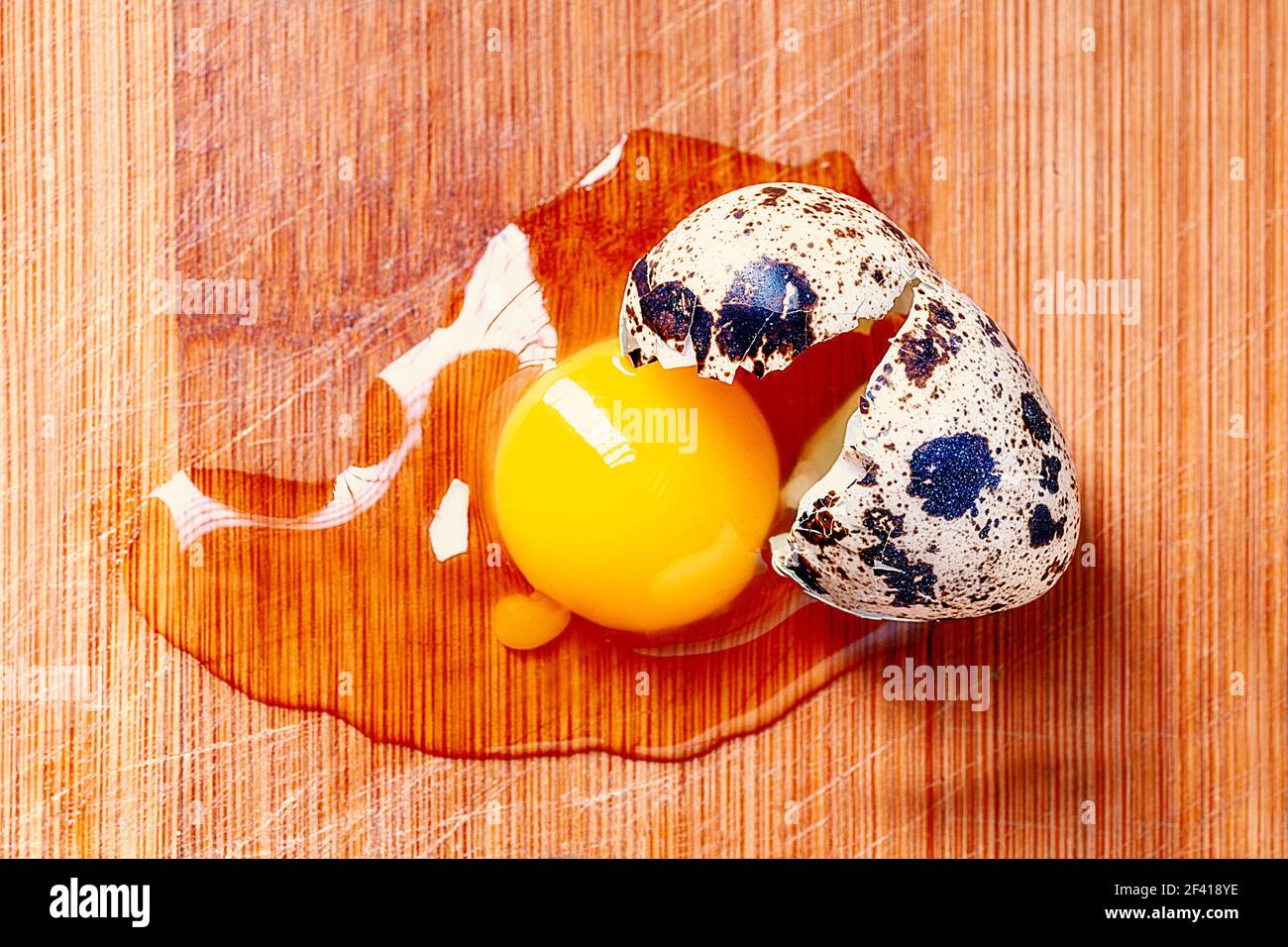 Broken Quail Egg On Wooden Cooking Board Top View. Broken Quail Egg On Wooden Board Top View Stock Photo