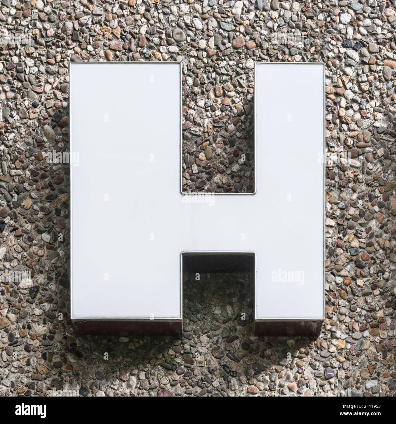 White letter H from the 70s on a concrete wall Stock Photo