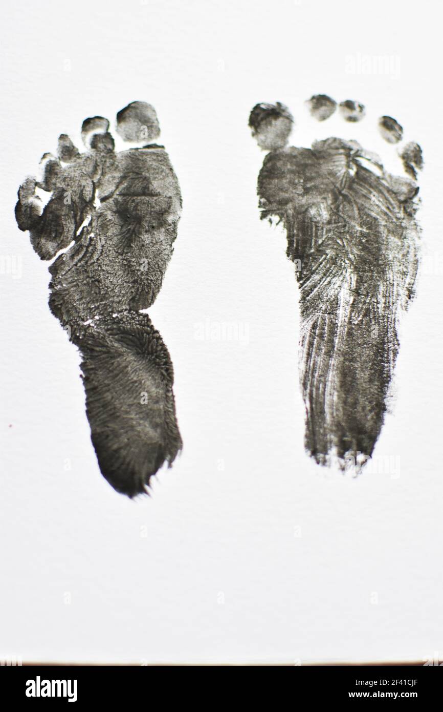 Pair of baby's footprints inked on paper. Baby foot painting. Black