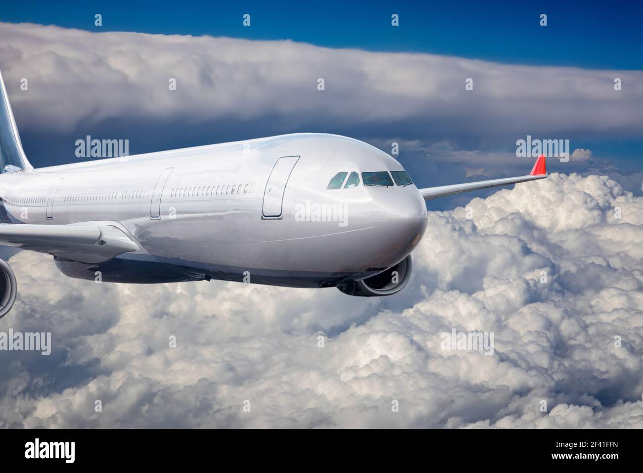 Passenger Airliner flying in the clouds Stock Photo