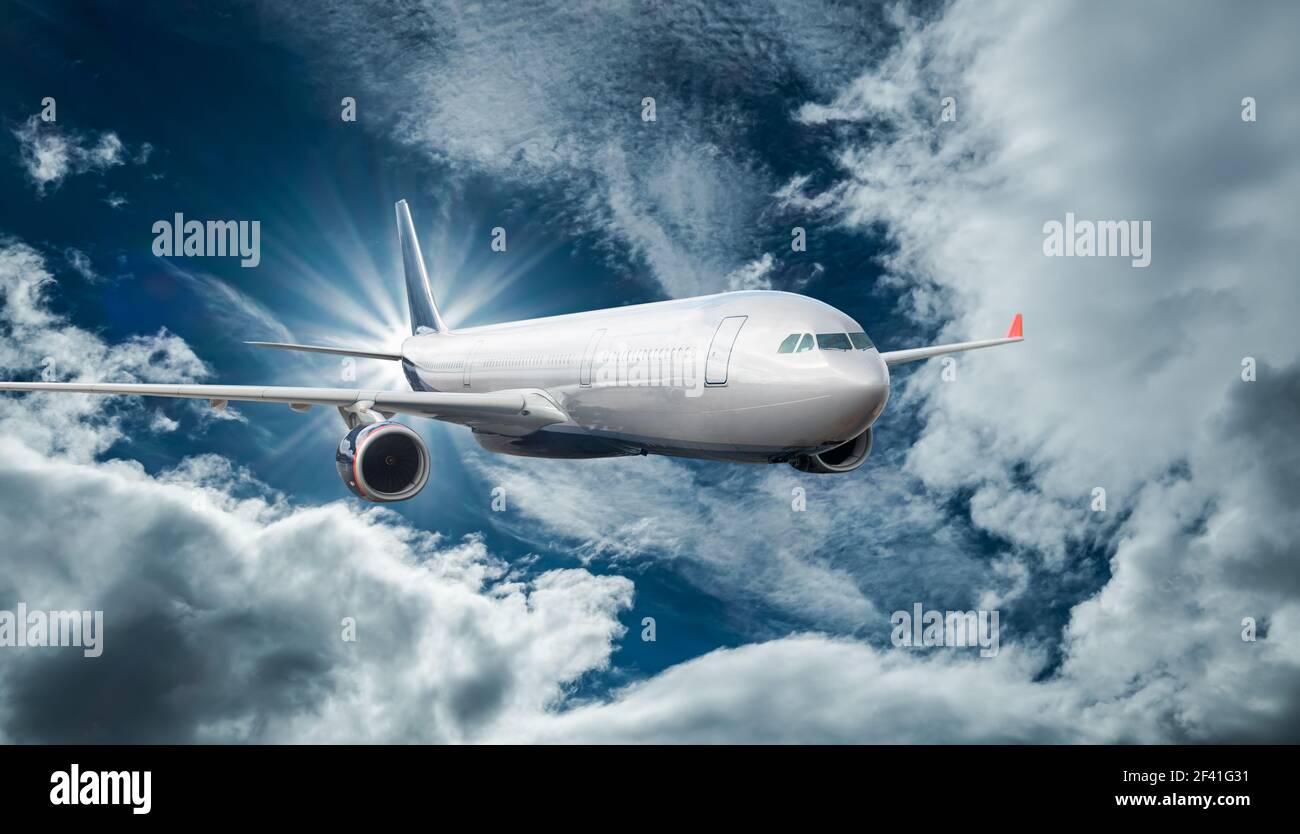 Passenger Airliner flying in the clouds Stock Photo