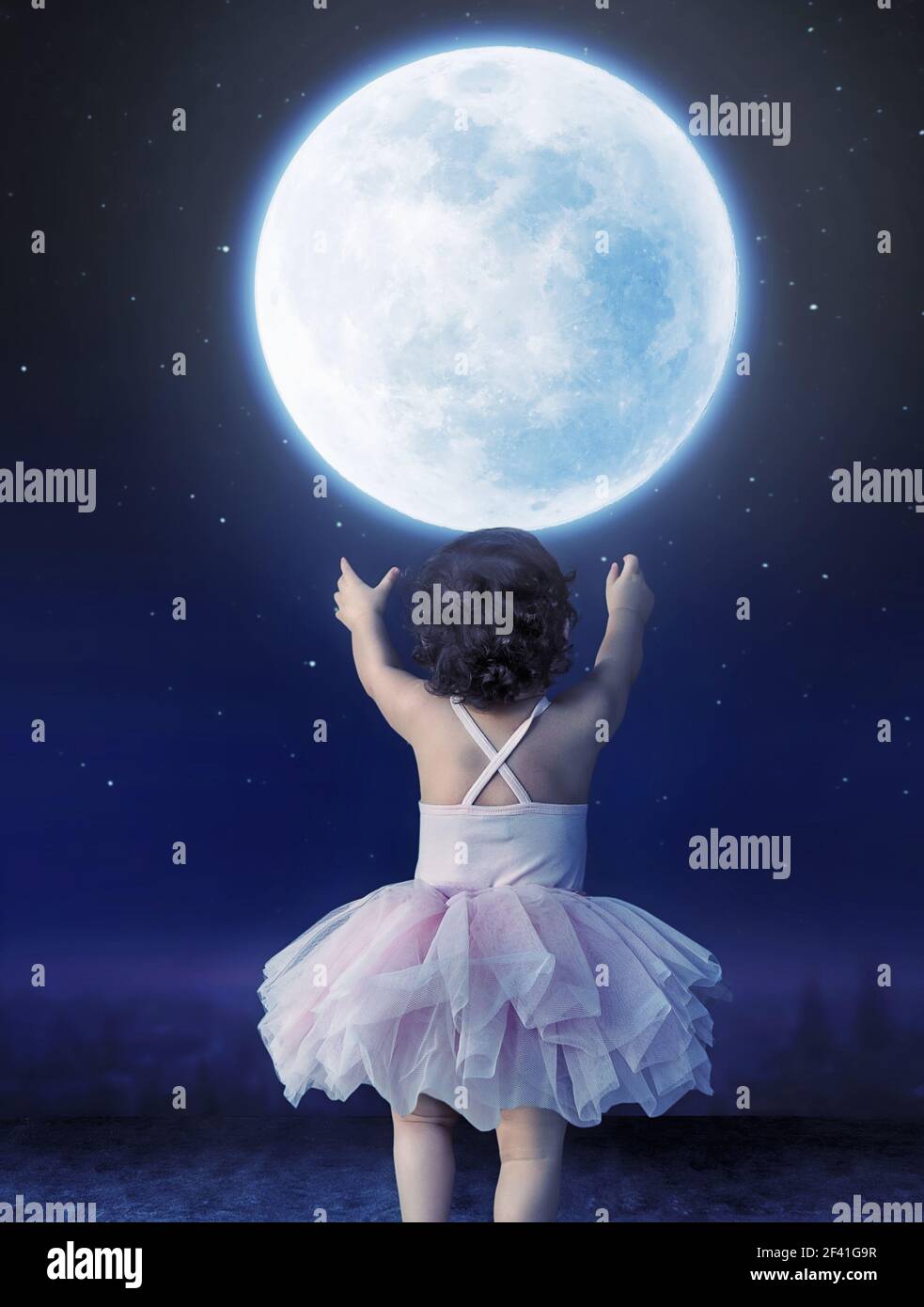 Cute baby girl reaching to the moon Stock Photo