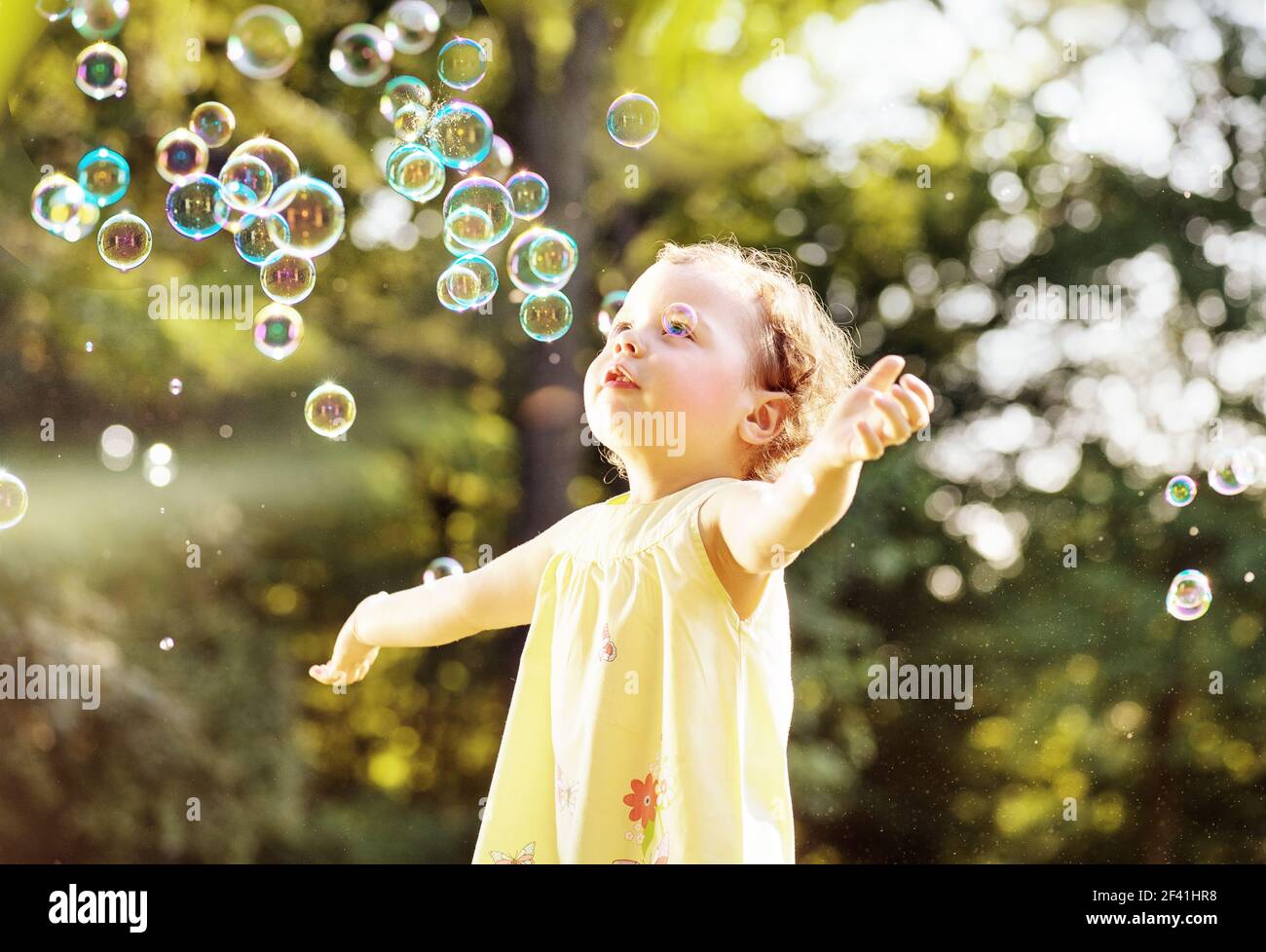 Little girl blowing soap bubbles in the summer park Stock Photo - Alamy