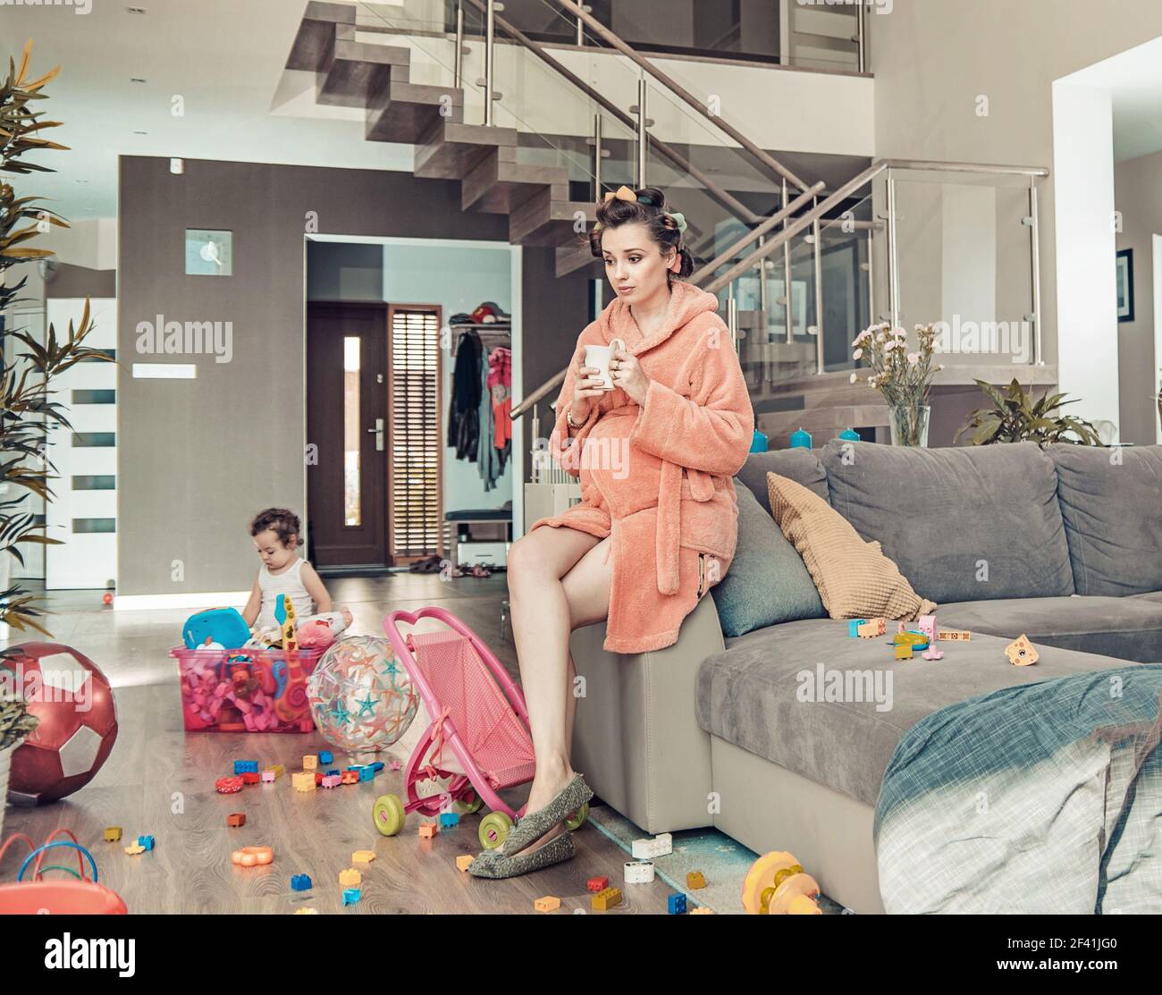 Young pregnant mother and her little daughter at home Stock Photo