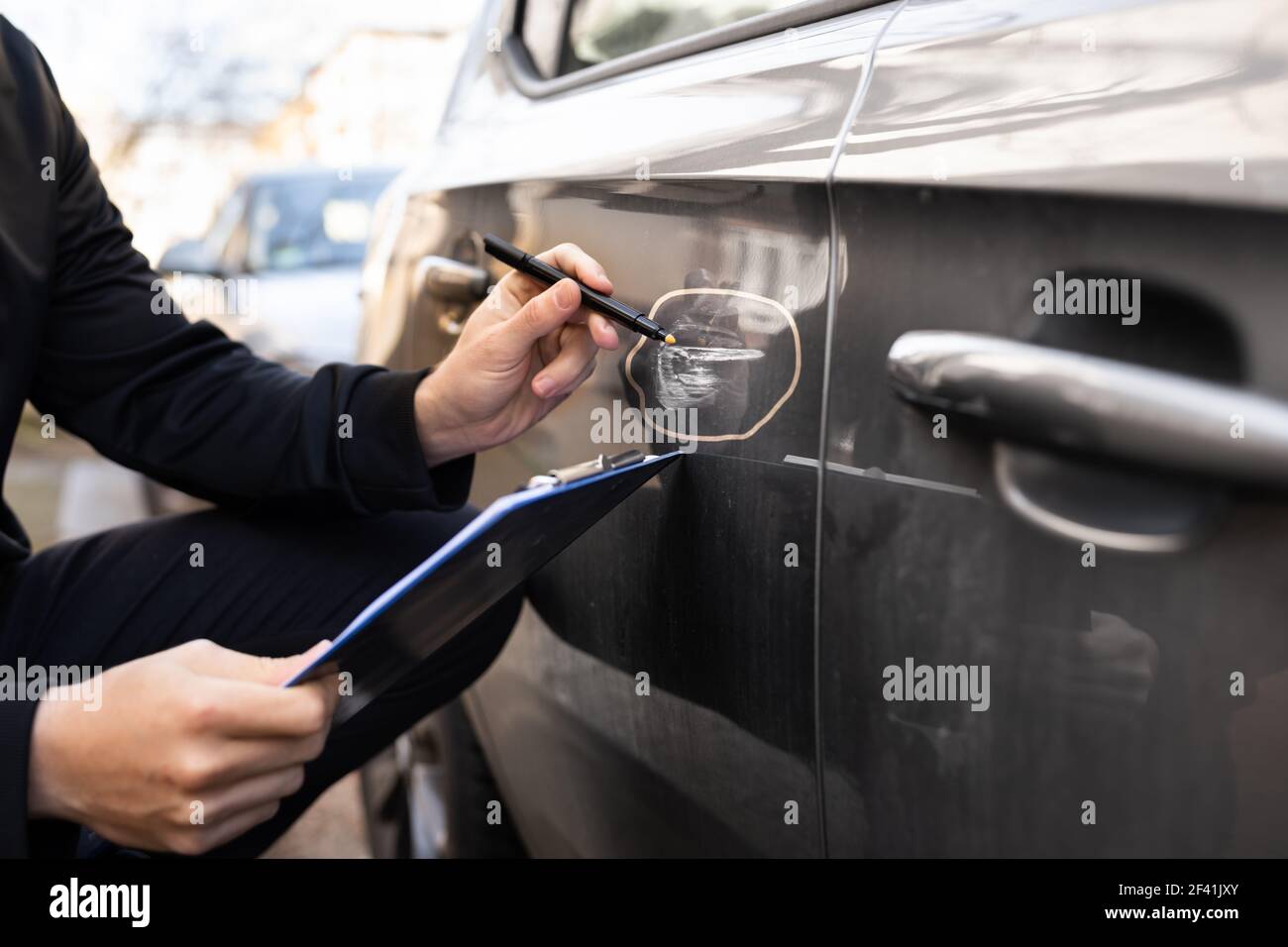 Insurance Agent Or Adjuster Inspecting Car After Accident Stock Photo