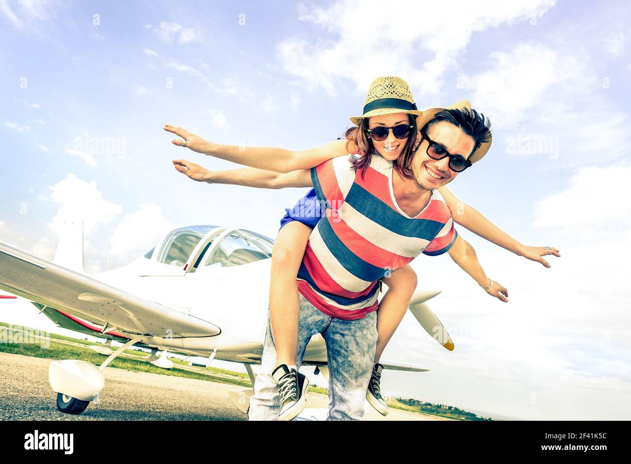Happy hipster couple in love on airplane travel honeymoon vacation - Summer concept with male and female models at exclusive trip excursion Stock Photo