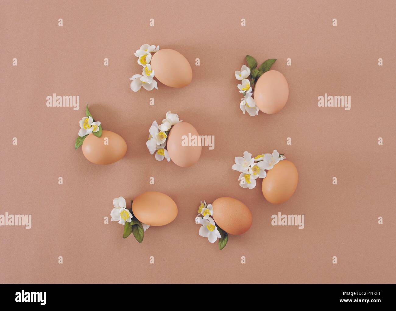 2021 Easter composition. Eggs with white flowers and leaves. Flat lay minimal background. Stock Photo