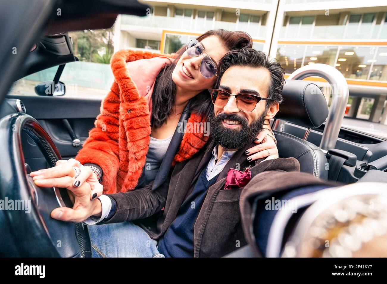 Handsome hipster boyfriend having fun with girlfriend - Happy couple taking selfie at car trip - Modern love relationship concept Stock Photo