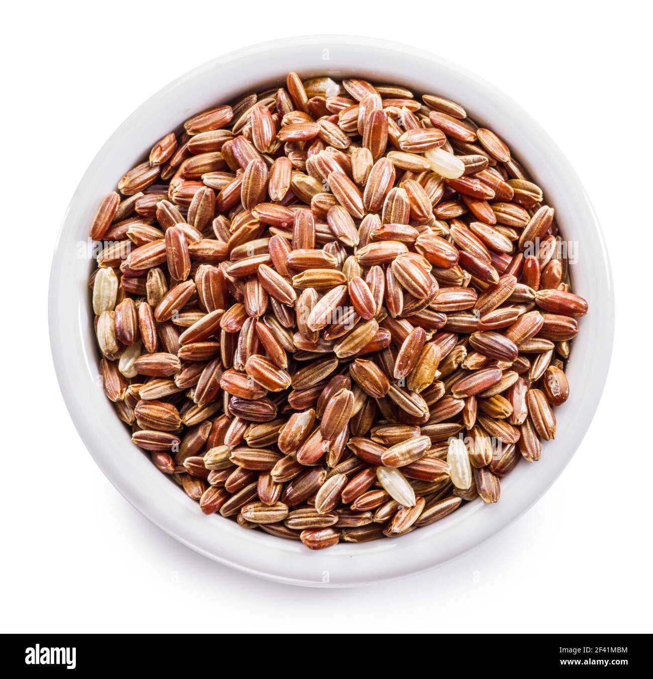 Brown rice - whole grain rice with outer hull or husk in ceramic bowl on white background. File contains clipping path. Stock Photo
