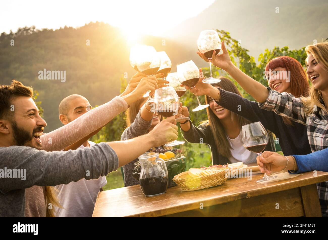 Happy friends having fun outdoors - Young people enjoying harvest time together at farmhouse vineyard countryside - Youth and friendship concept Stock Photo
