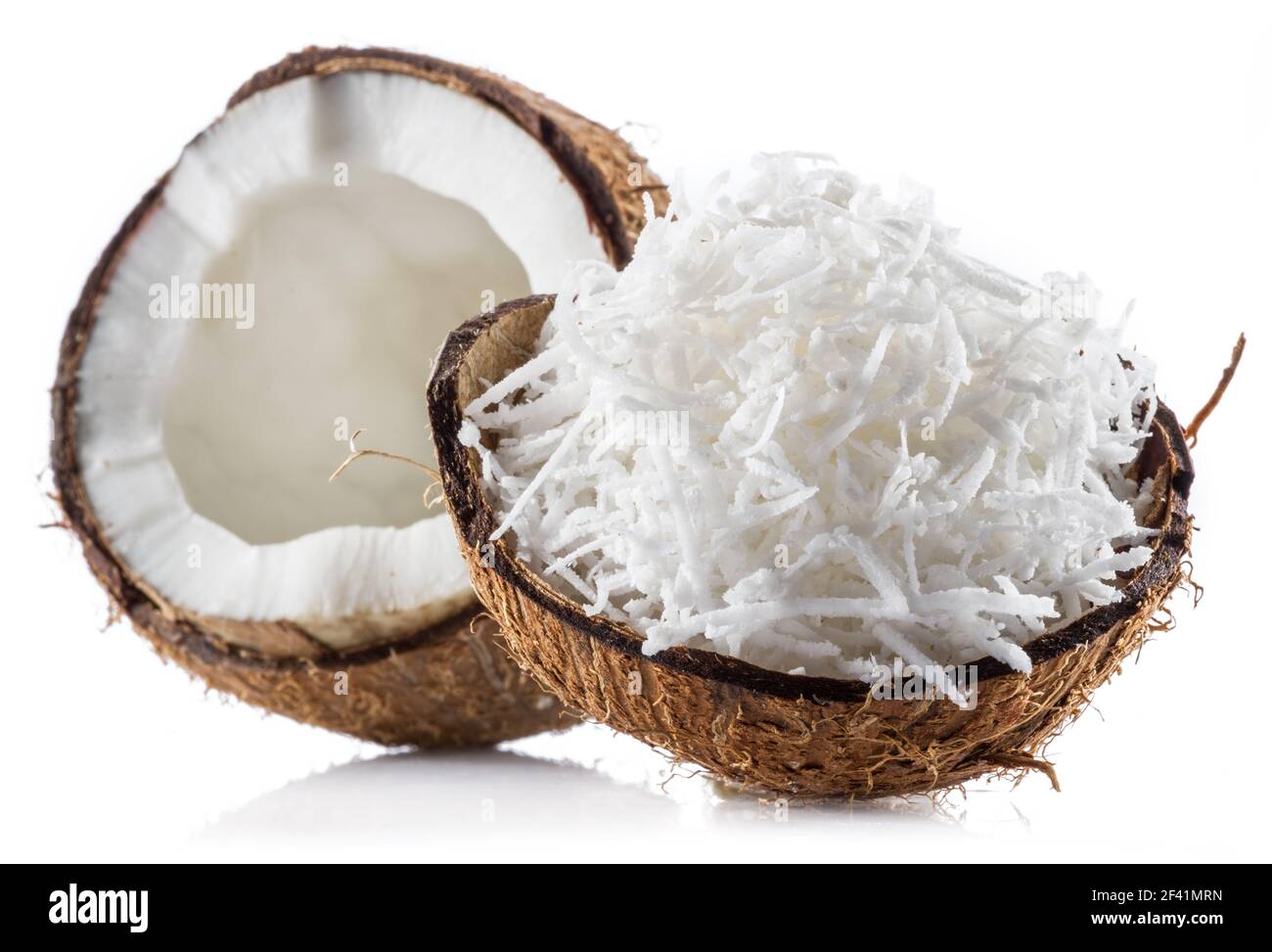 Coconut fruit and shredded coconut flakes in the piece of shell isolated on white background. Stock Photo