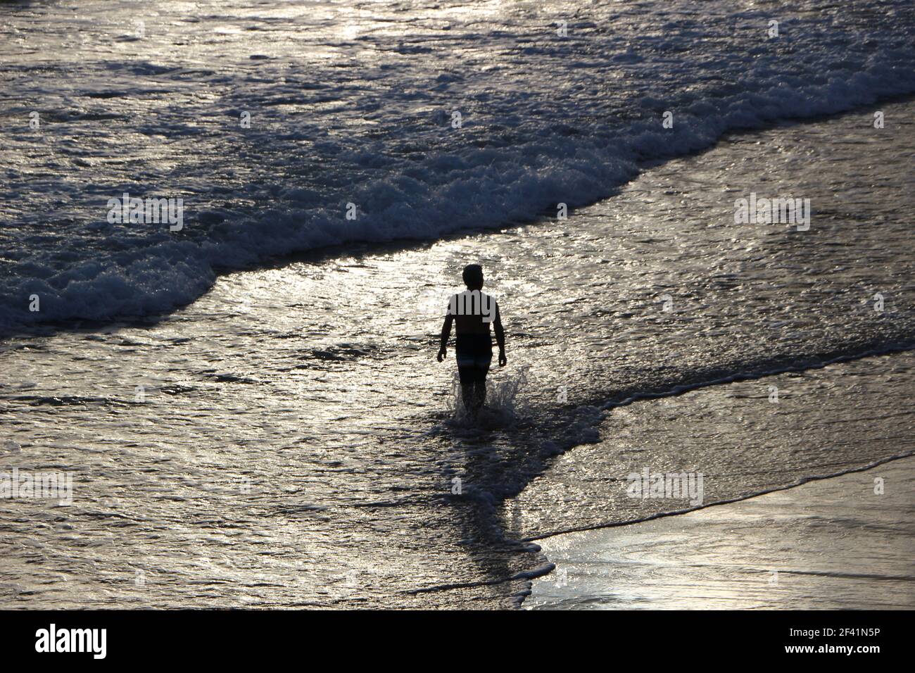 Senior man walking into the sea in swimming trunks on a cold winter morning for a swim Santander Cantabria Spain Stock Photo