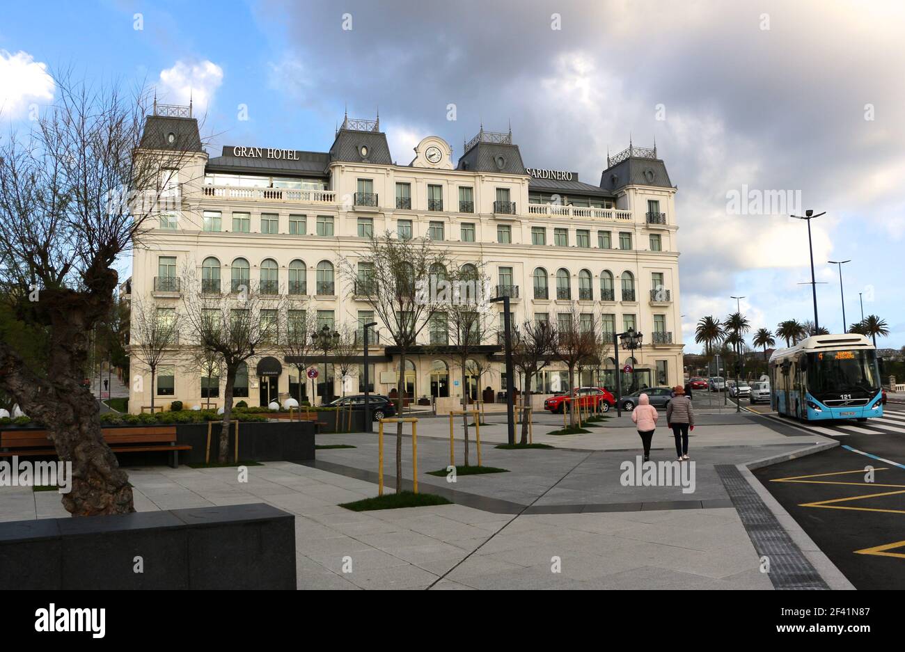 Front facade of the newly rebuilt Hotel Sardinero Plaza de Italia Santander Cantabria Spain Winter with a passing bus and pedestrians Stock Photo