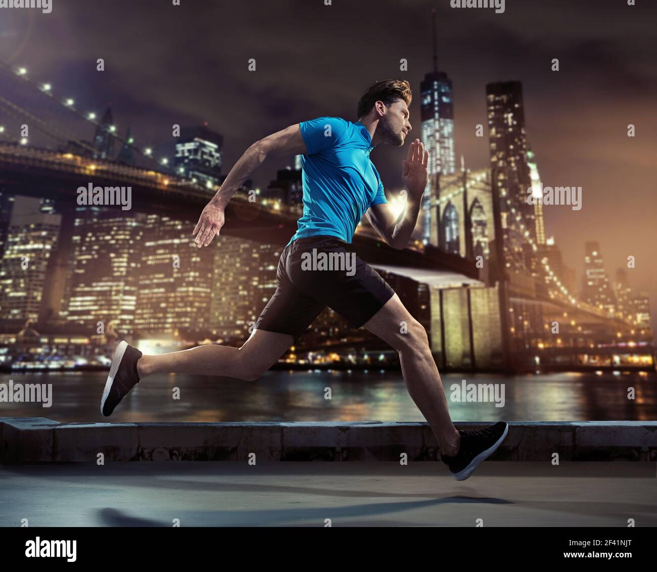 Handsome young jogger running through the city in the night Stock Photo