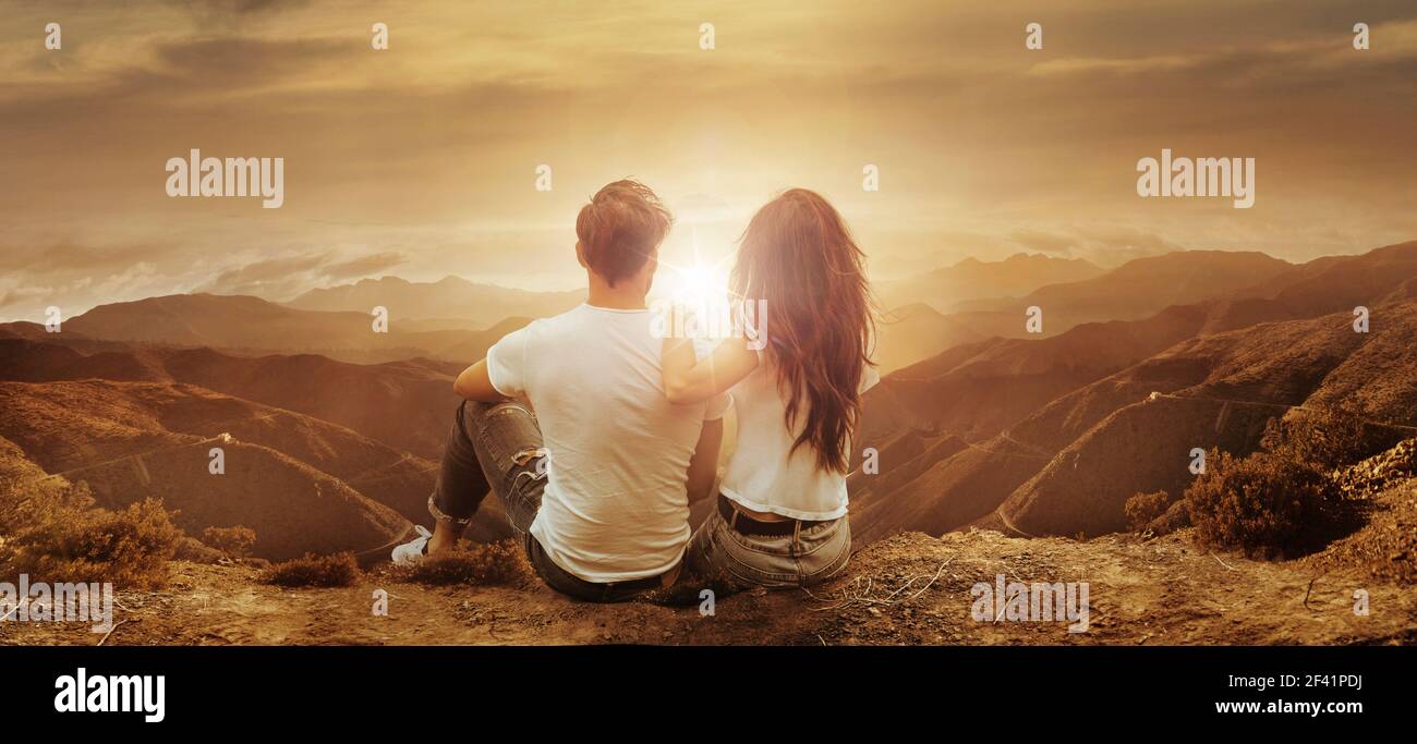 Young, relaxed couple watching a beautiful sunset Stock Photo