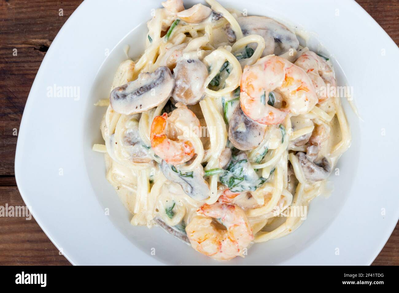 creamy keto alfredo shrimp and mushroom pasta with spinaches with palm
