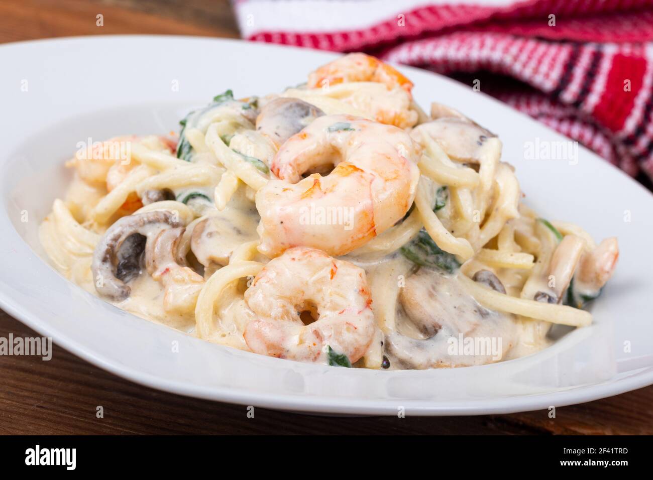 creamy keto alfredo shrimp and mushroom pasta with spinaches with palm