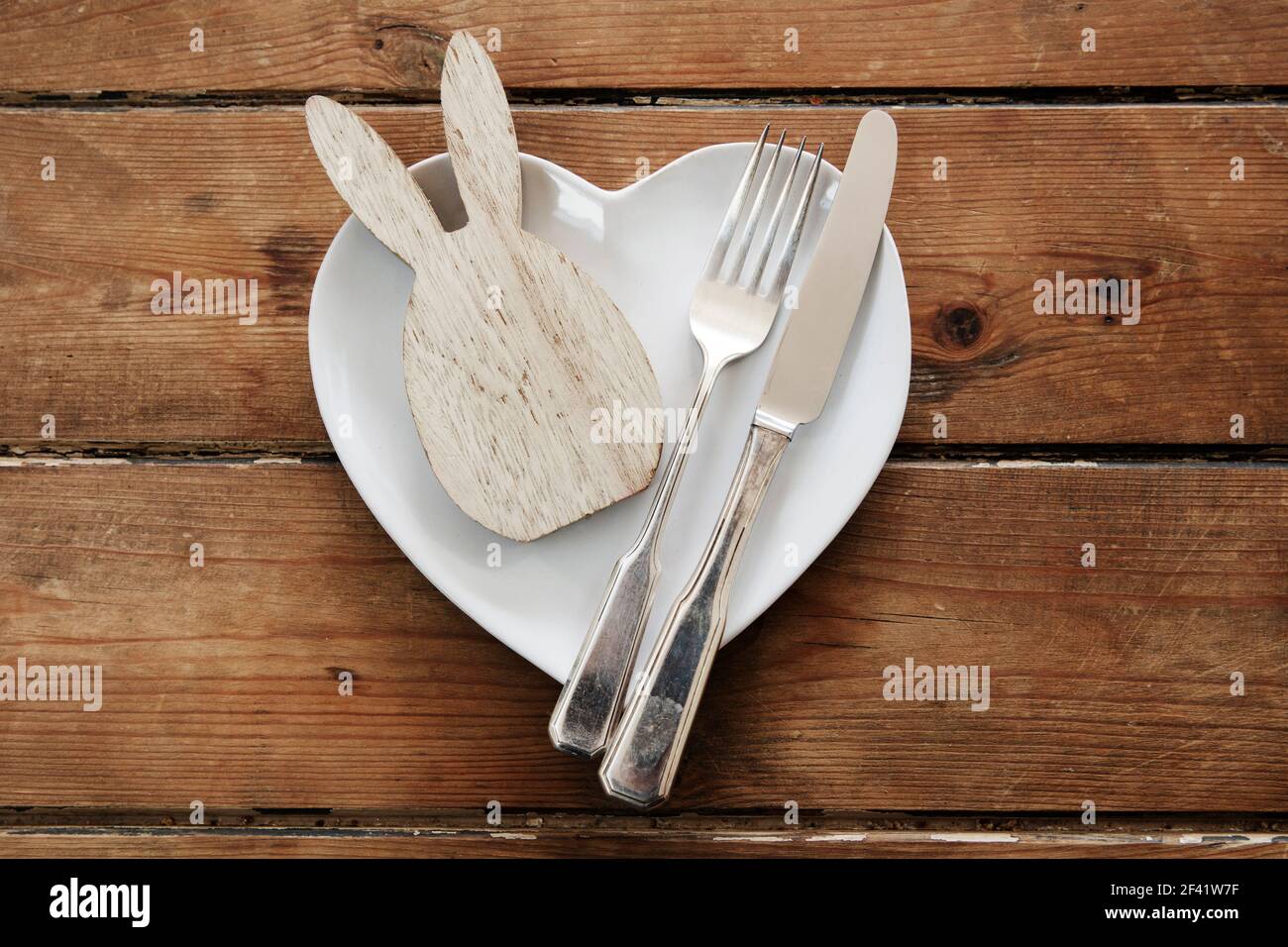 Easter table overhead view with a rabbit shape on a plate with cutlery Stock Photo
