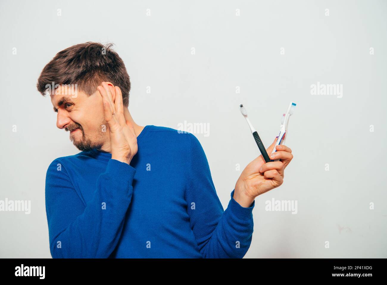 man holding toothbrushes Stock Photo
