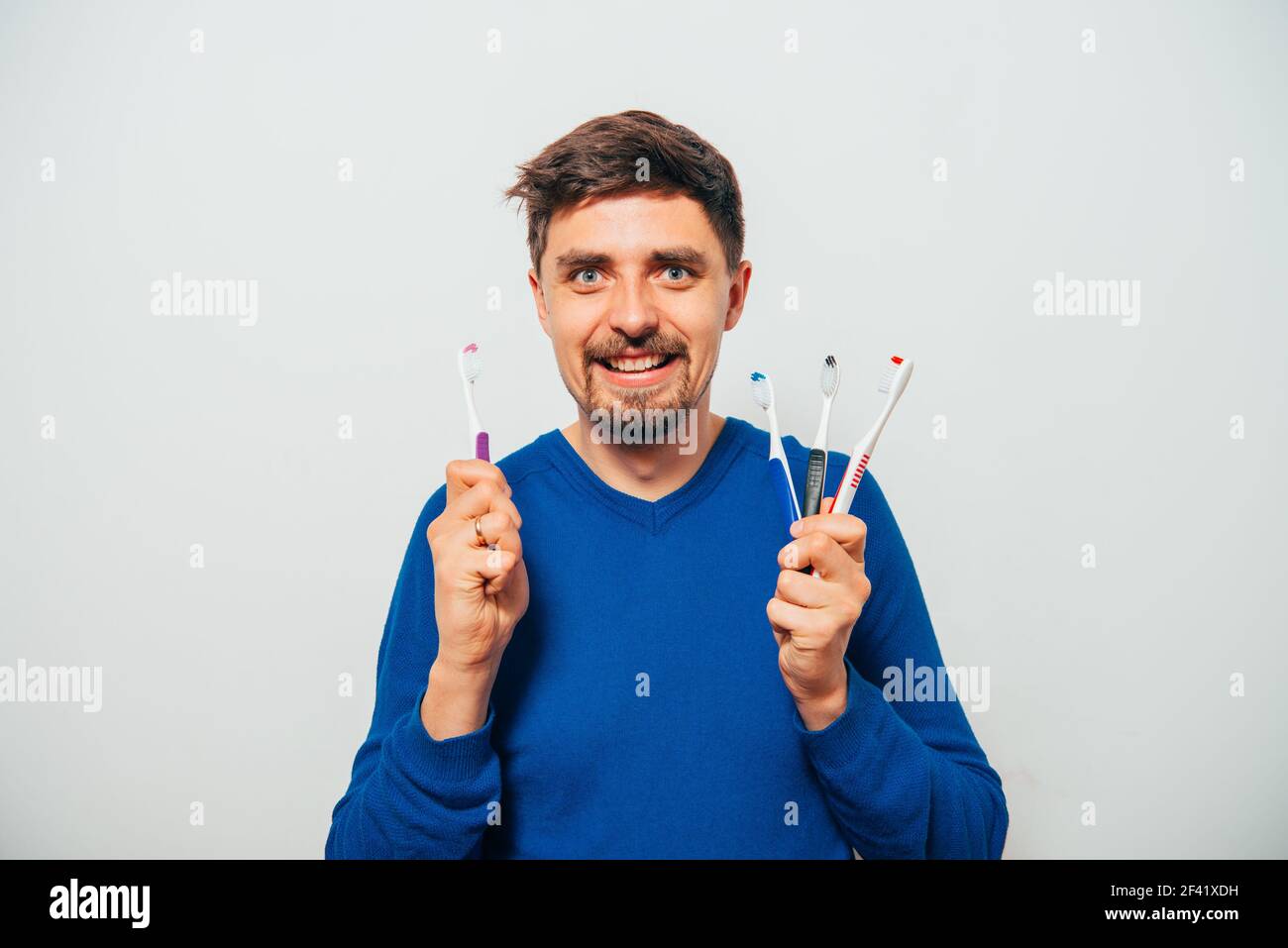 man holding toothbrushes Stock Photo