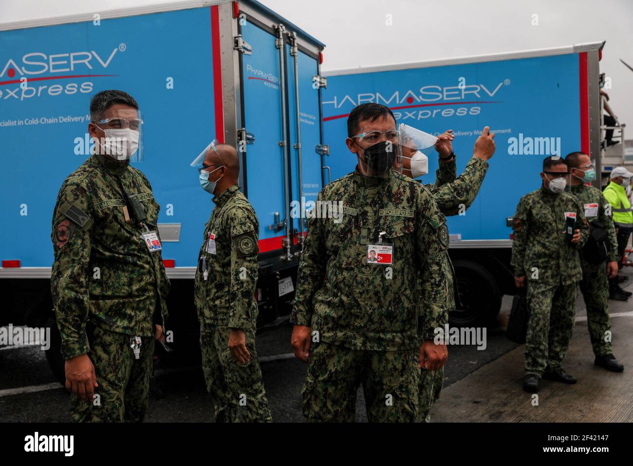 Policemen watch as airport personnel transfer crates of mock vaccines during a simulation at the Ninoy Aquino International Airport (NAIA) Terminal 2 in Pasay City, Metro Manila, Philippines. Stock Photo