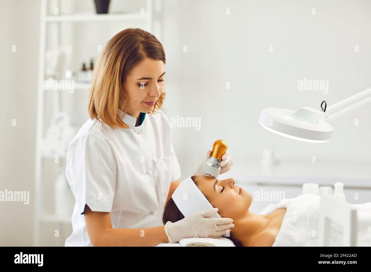 Young good looking woman enjoying mesotherapy ultrasonic skin rejuvenation procedure Stock Photo