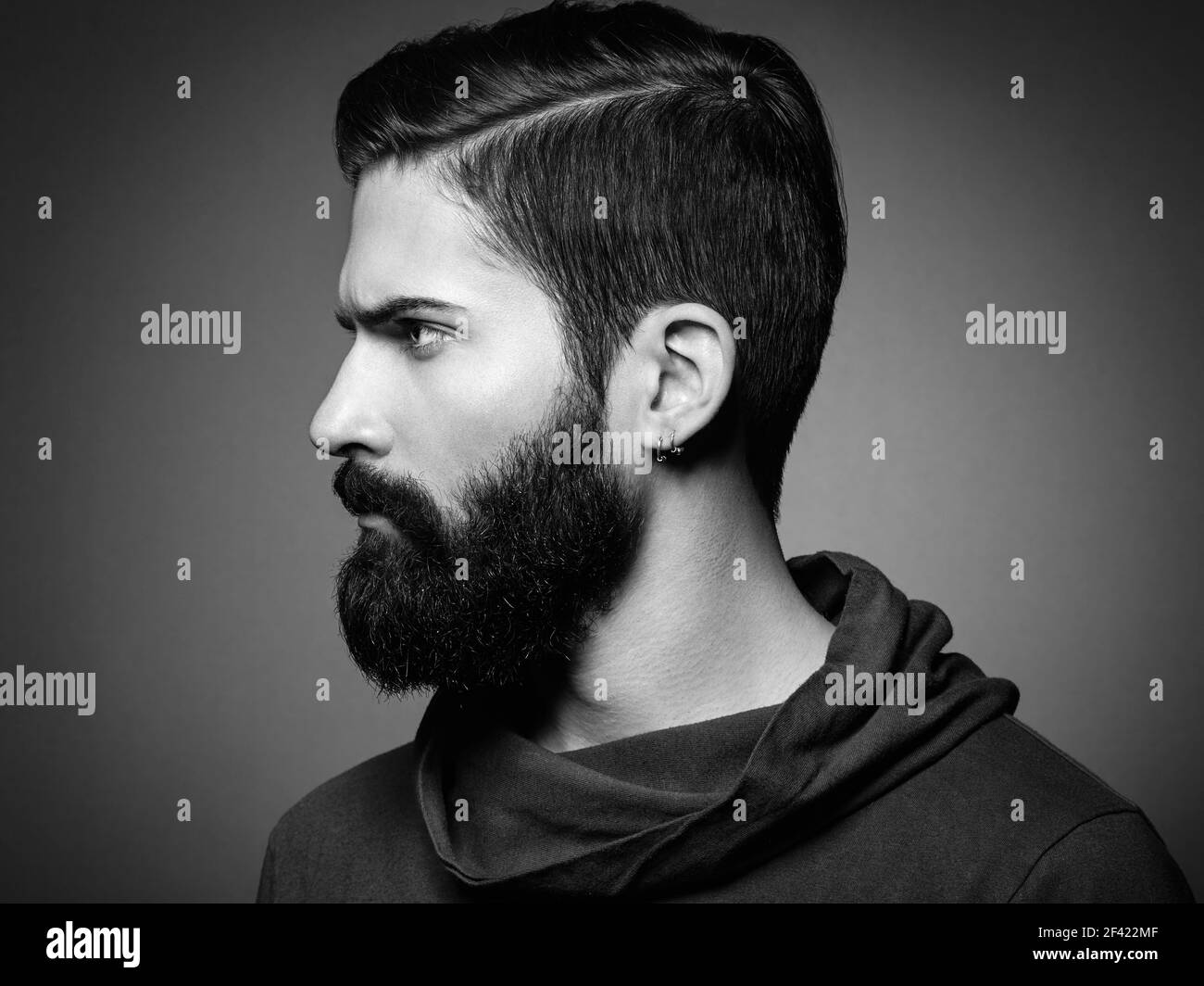 Portrait of handsome man with beard and mustache. Close-up image of serious brutal bearded man on dark background. Black and white photography Stock Photo