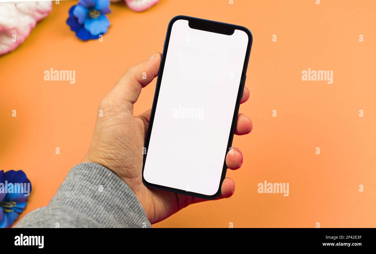 Man using smartphone mockup with blank white screen, flat lay workspace design concept Stock Photo