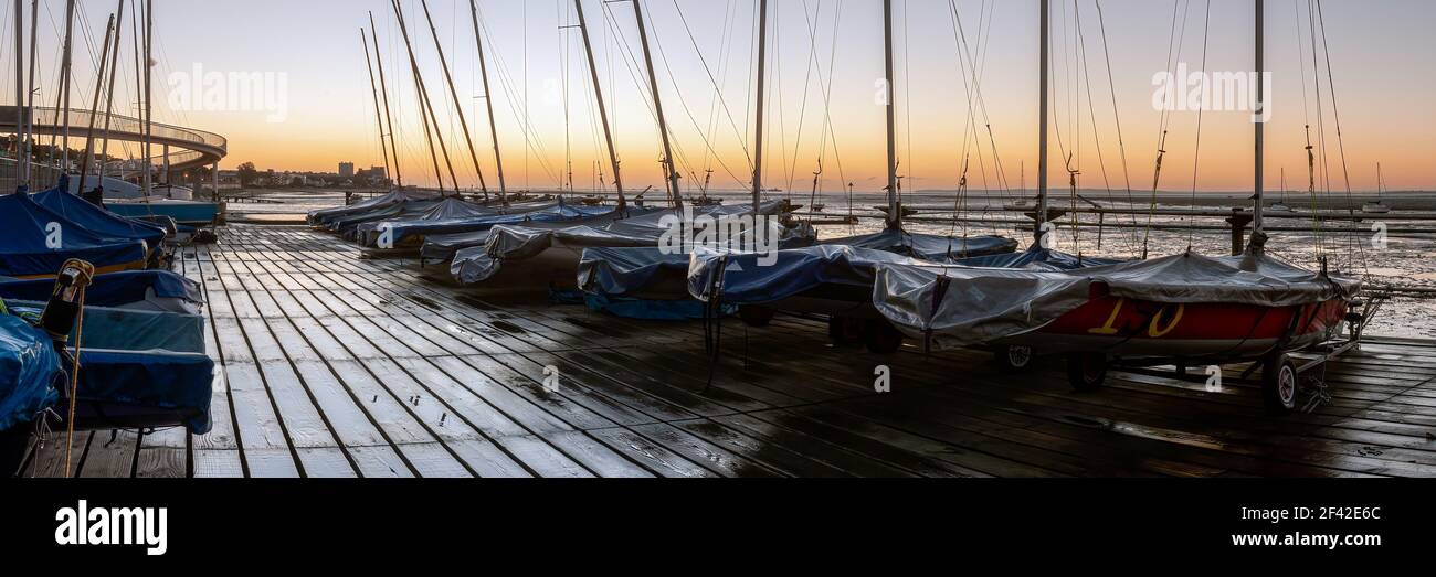 SOUTHEND-ON-SEA, ESSEX, UK - OCTOBER 24, 2010:  Panorama view of dingies on a wet Wooden jetty at Chalkwell at dawn Stock Photo
