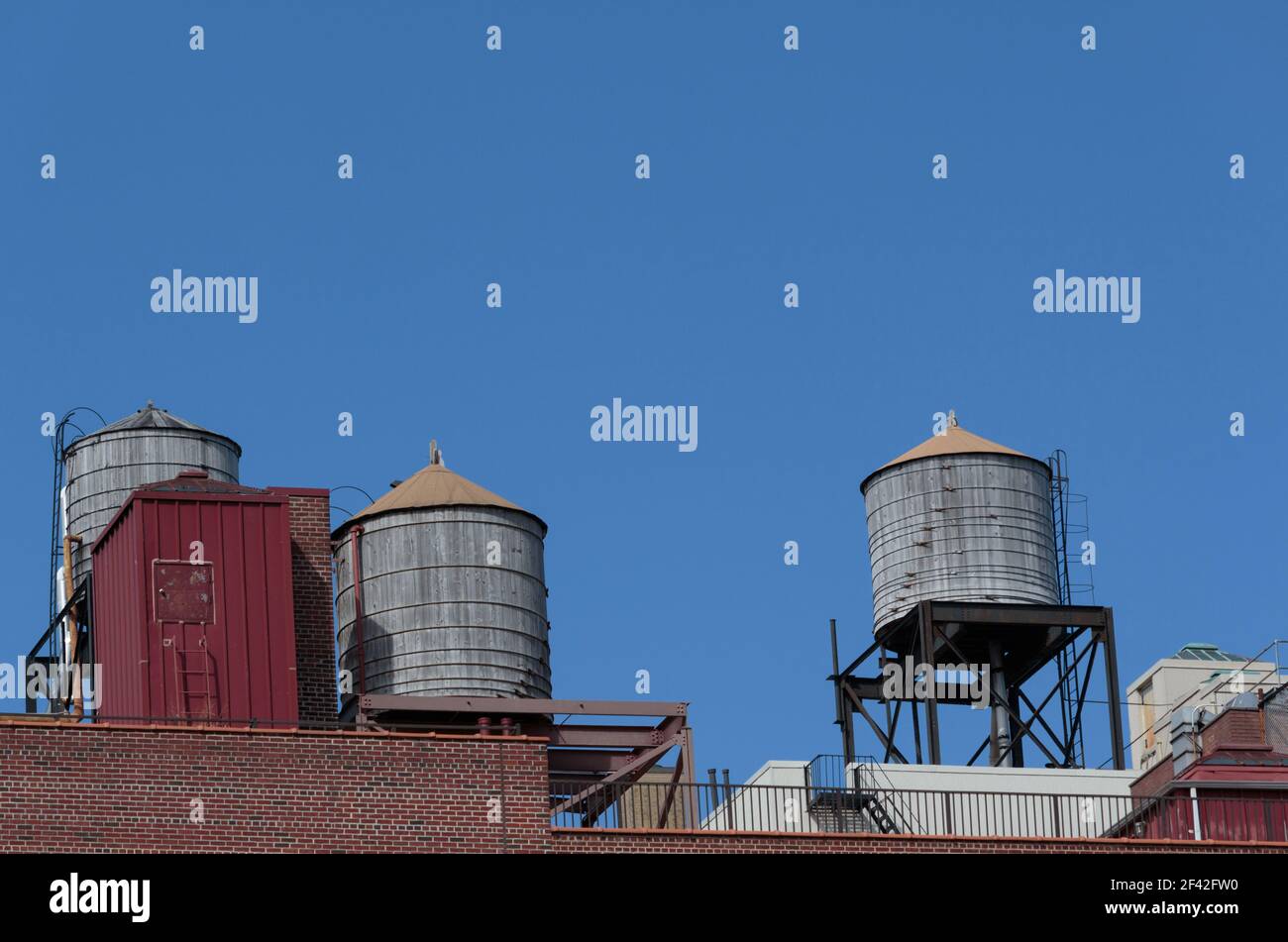 water tanks on a new york city apartment building rooftop against a
