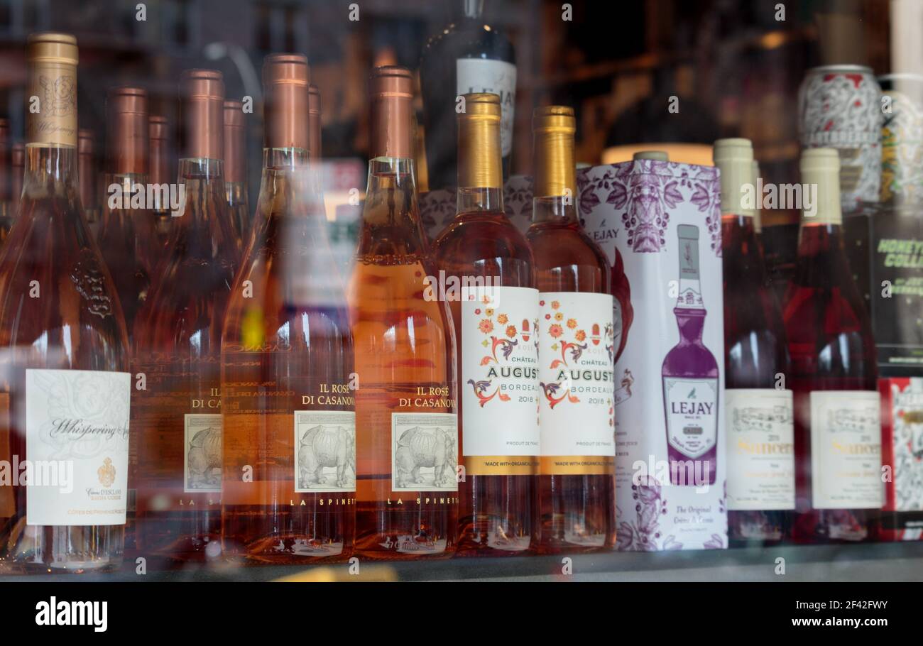 liqour store display window with bottles of  rose wine, la spinetta il rose di casanova, chateau auguste bordeax and lejay creme de cassis liquer Stock Photo