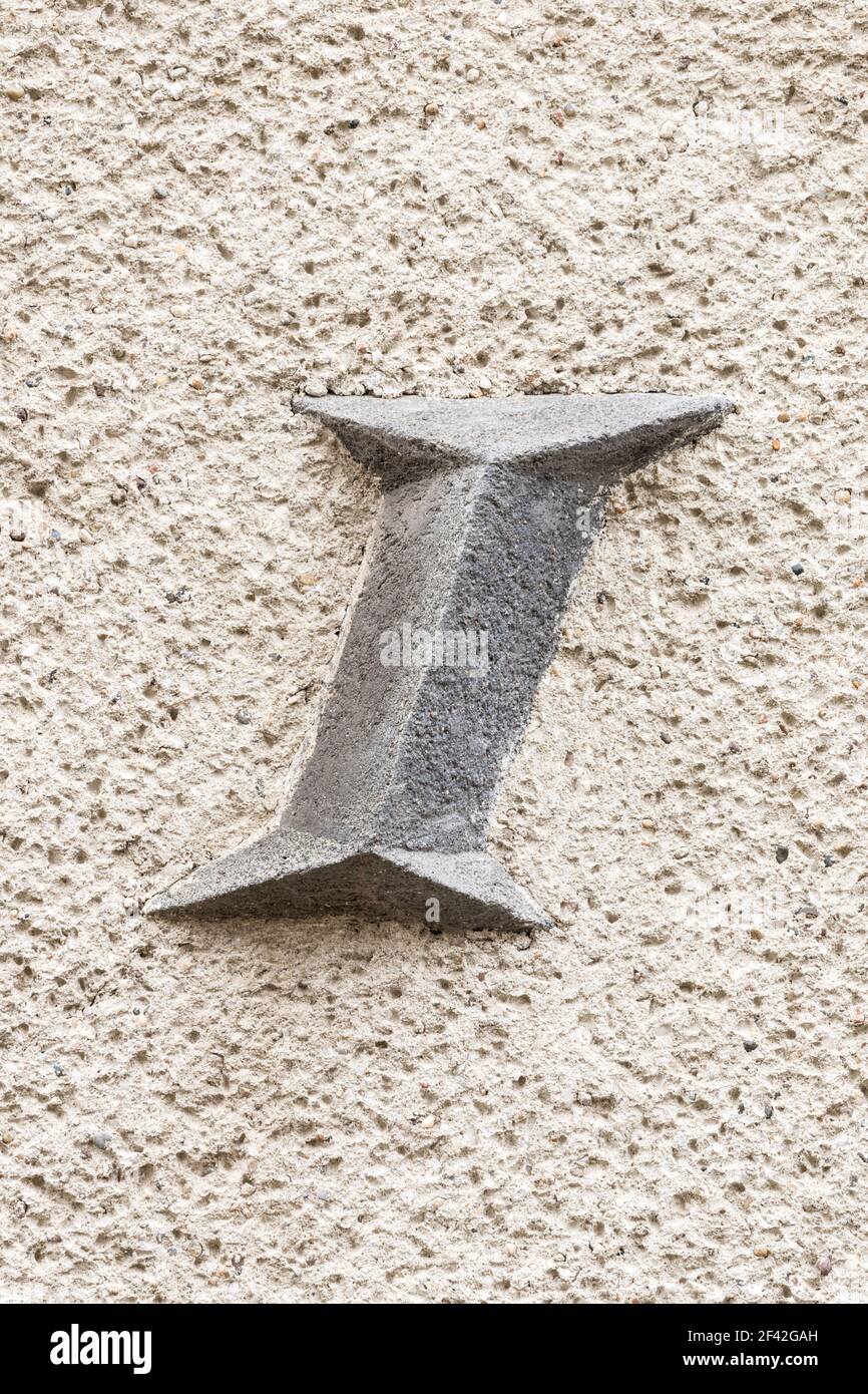Large letter I(i) on roughly plastered wall Stock Photo