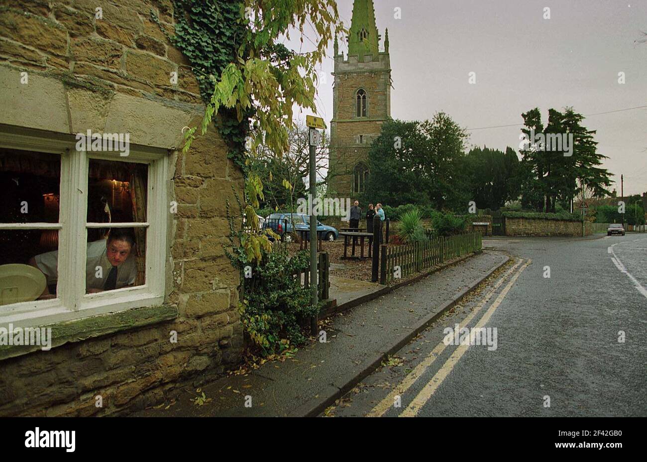 STEVE HUGHES THE LANDLORD OF THE  PEACOCK INN WHO IS IN FAVOUR OF  CROSSROADS COMING TO THE VILLAGE, LOOKS OUT DOWN THE MAIN STREET IN REDMILE.24/11/00 PILSTON. Stock Photo