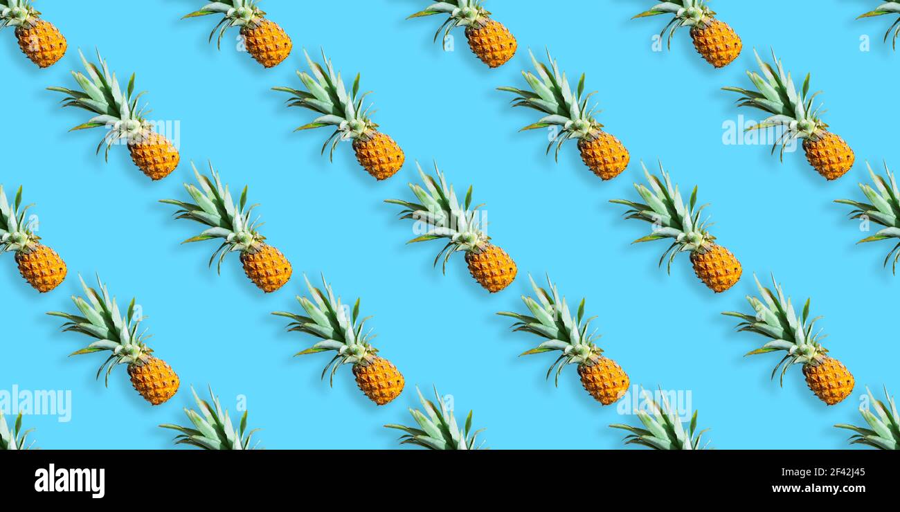 Pattern of ripe pineapples isolated on blue background. Seamless pattern Stock Photo