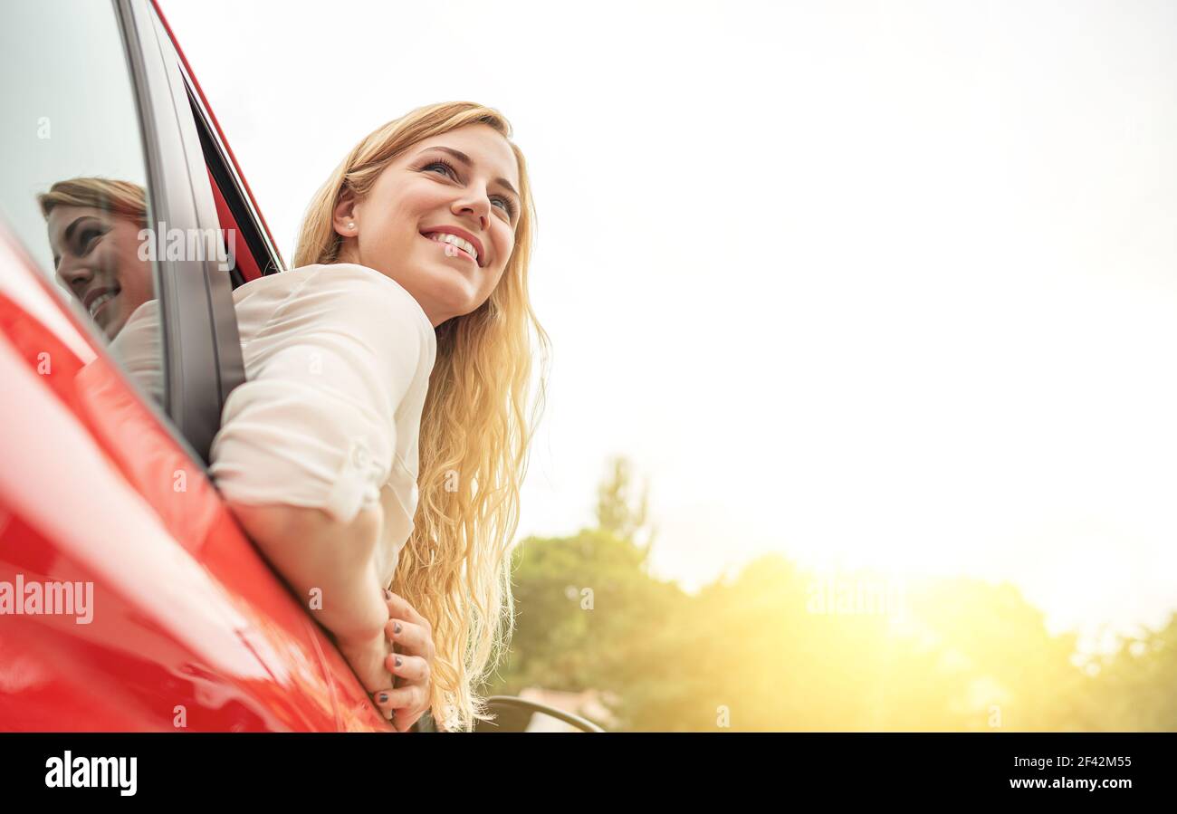 Happy beautiful woman is driving a red car Stock Photo - Alamy