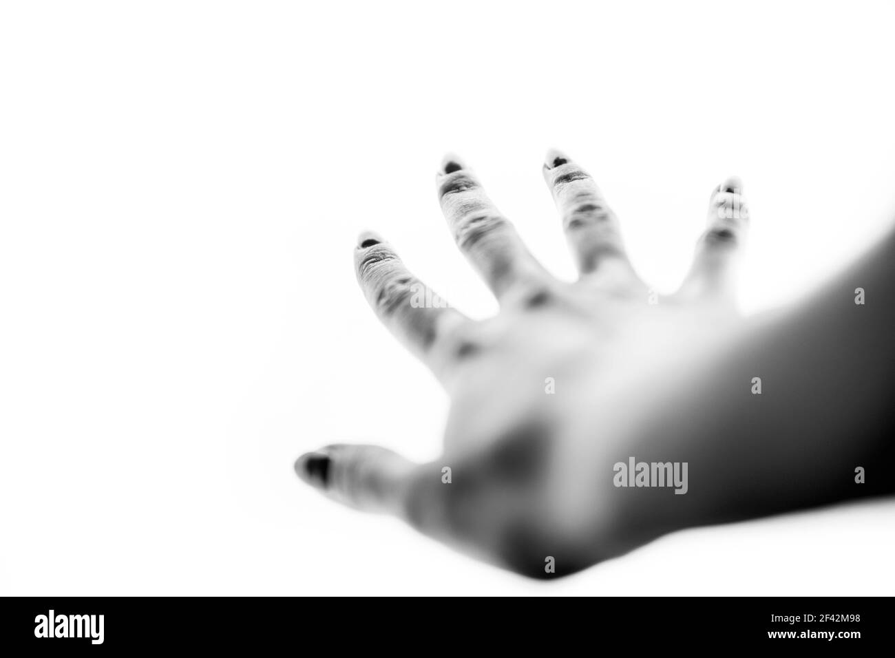 Female hand on a white background with spread fingers. Bye gesture. BW photo, blurred soft focus. Stock Photo