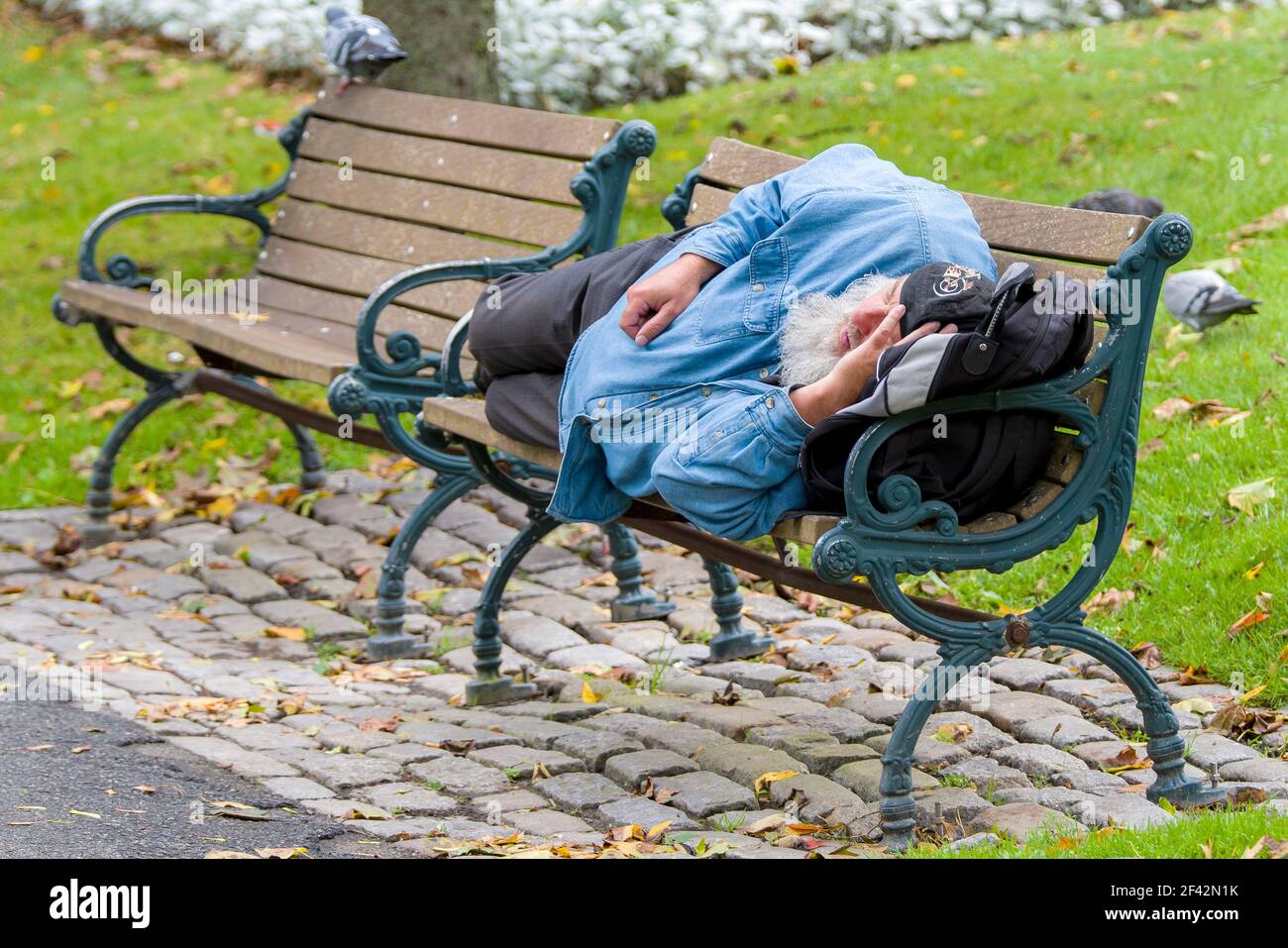 Saint John, New Brunswick, Canada - 2017-10-10: Man passed out on a park bench. Stock Photo