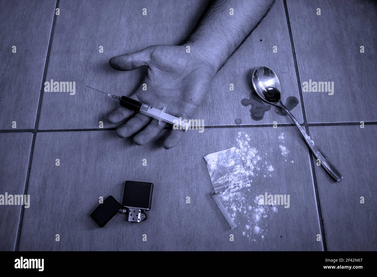Hand lying on the floor with overdose Stock Photo